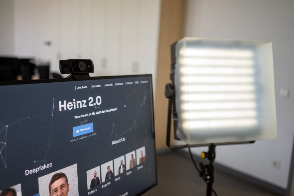 Bildschirm mit Webcam, Website Heinz 2.0 ist sichtbar, daneben eine große Lampe